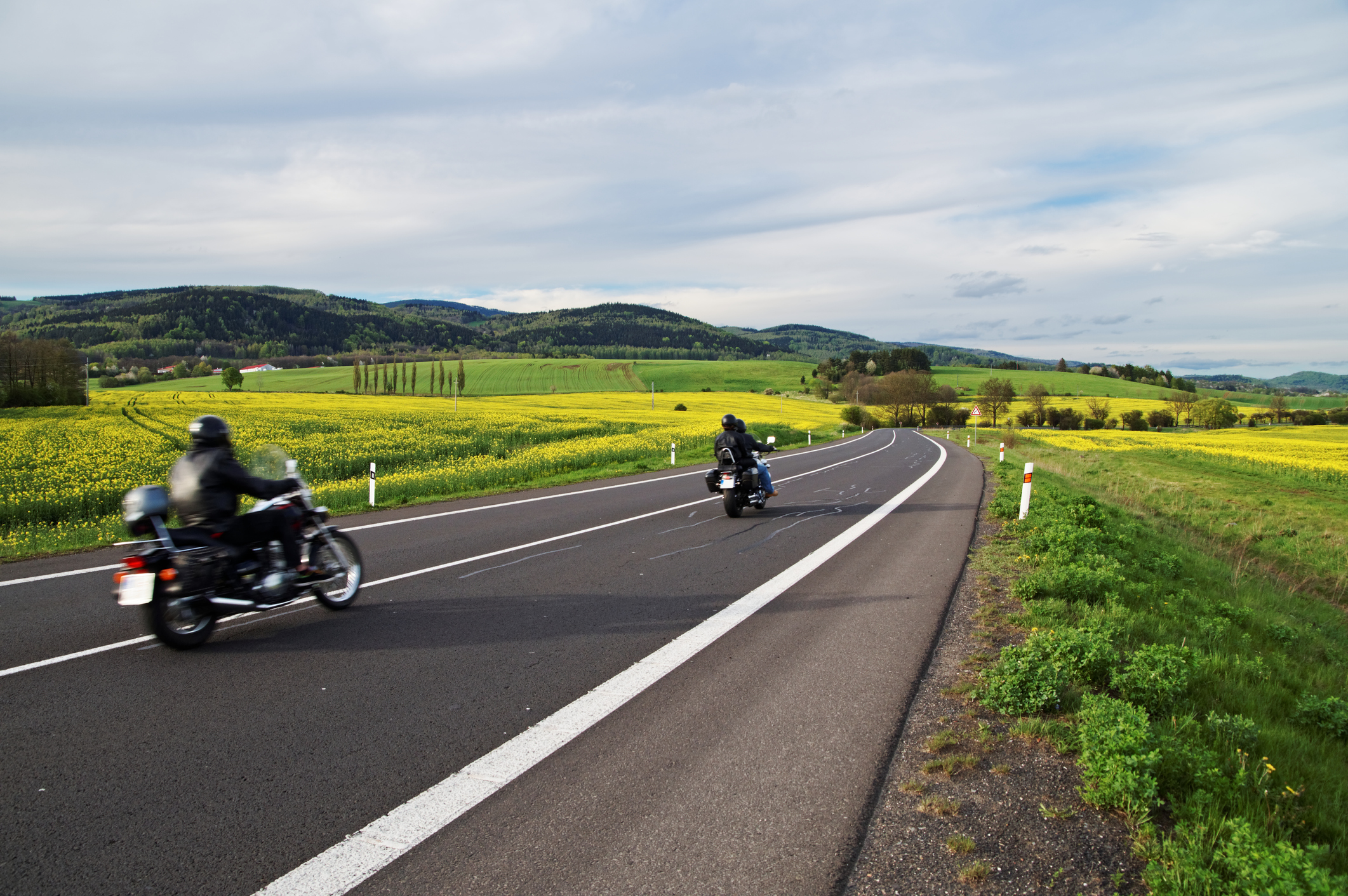 Motorcycles traveling along an empty road