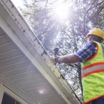 Claim agent checking the roof. Mature claim agent determine cost of repairs to reimburse the losses. Low angle view, rear view