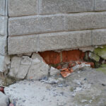 The Silent Bedrock: A Forensic Engineering Guide to Structural Foundation Failures Foundation house wall damage from wetness. Foundation walls without waterproofing. Cracked foundation wall corner.